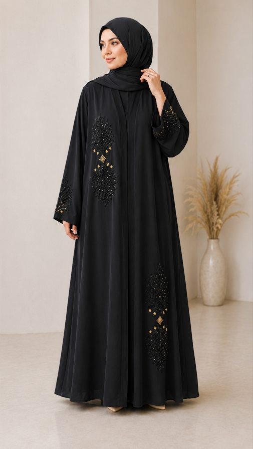 Woman wearing a black abaya with gold embellishments in a minimalistic setting.
