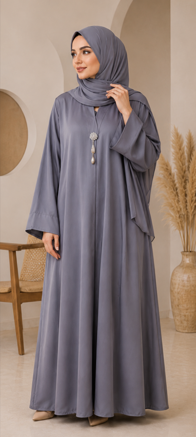 Woman wearing a long gray dress with a hijab in an indoor setting.