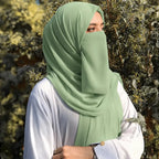 Woman wearing sage green georgette hijab with matching niqab outdoors